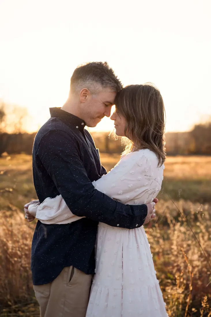 A couple standing forehead to forehead at dusk