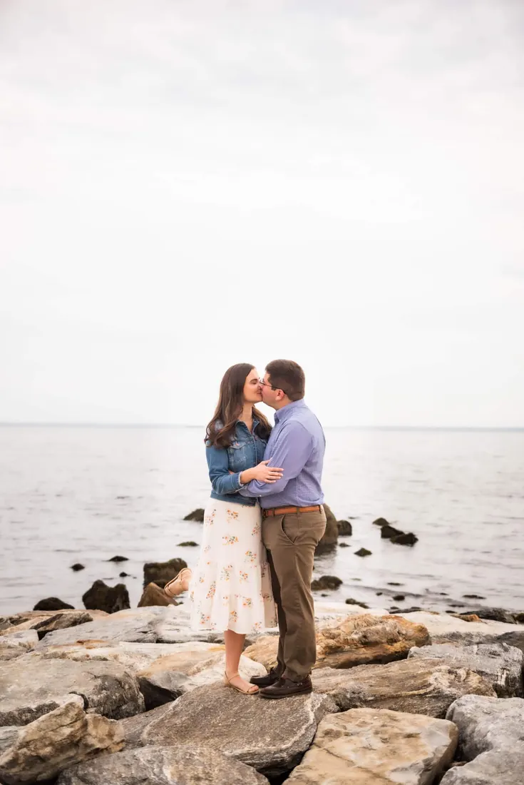 A couple sitting on rocks by the water