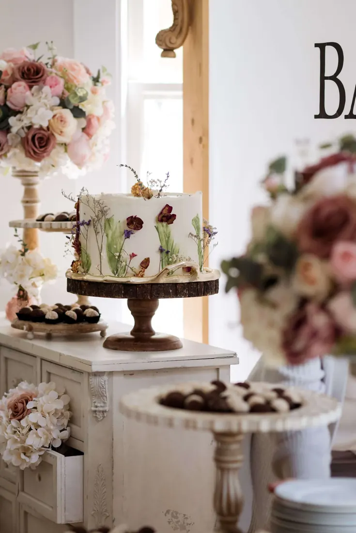 A dessert table with flowers at a baby shower