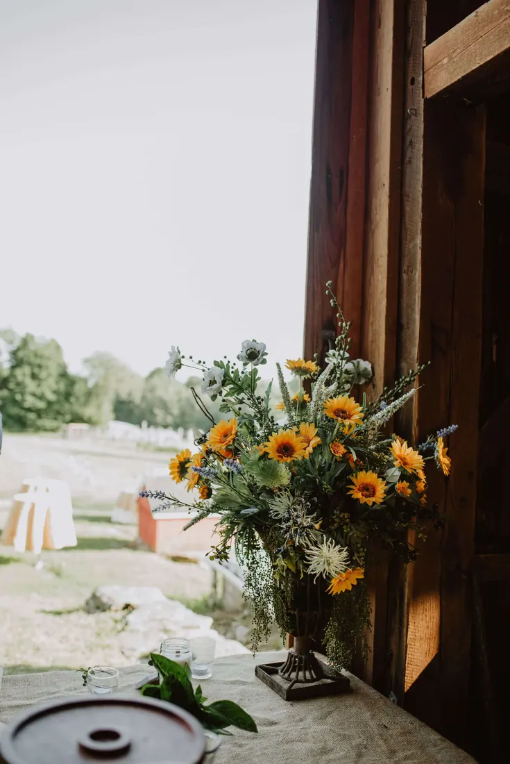 Sunflowers arranged in a barn doorway before guests arrive