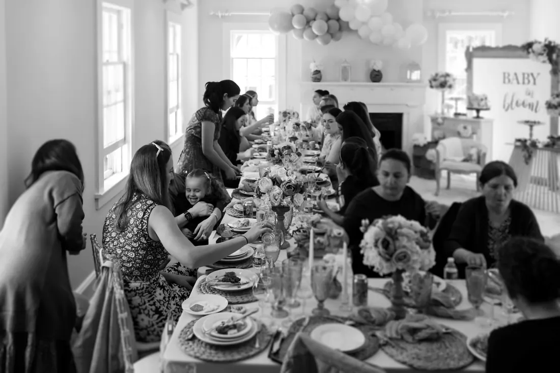 A long table full of guests at a baby shower