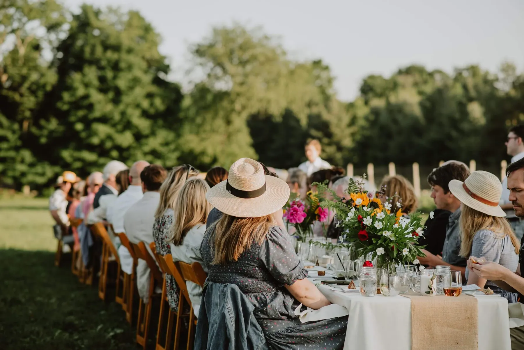 Guests seated at a long outdoor table at a summer celebration
