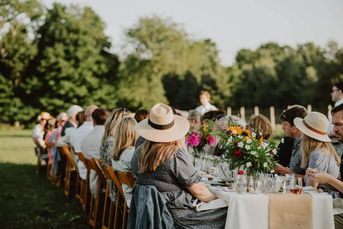Guests seated at a long outdoor table at a summer celebration