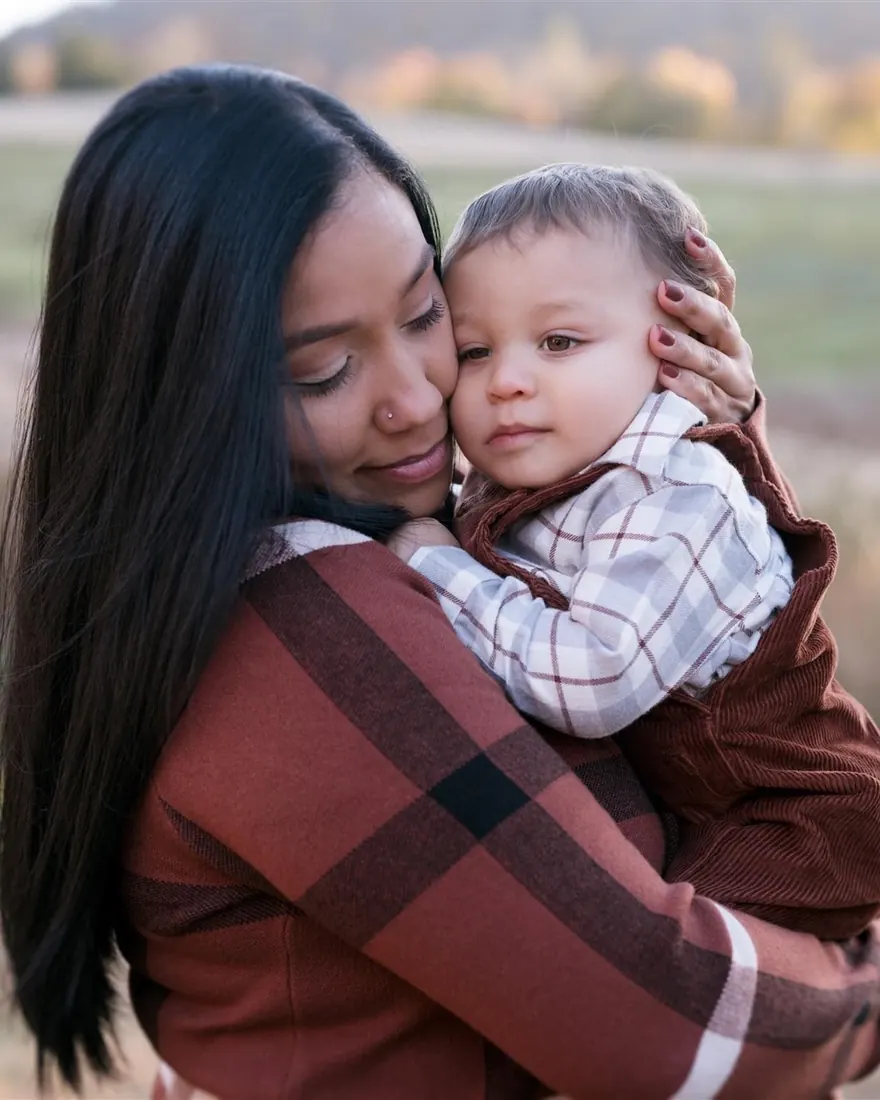 A mother holding her toddler outdoors