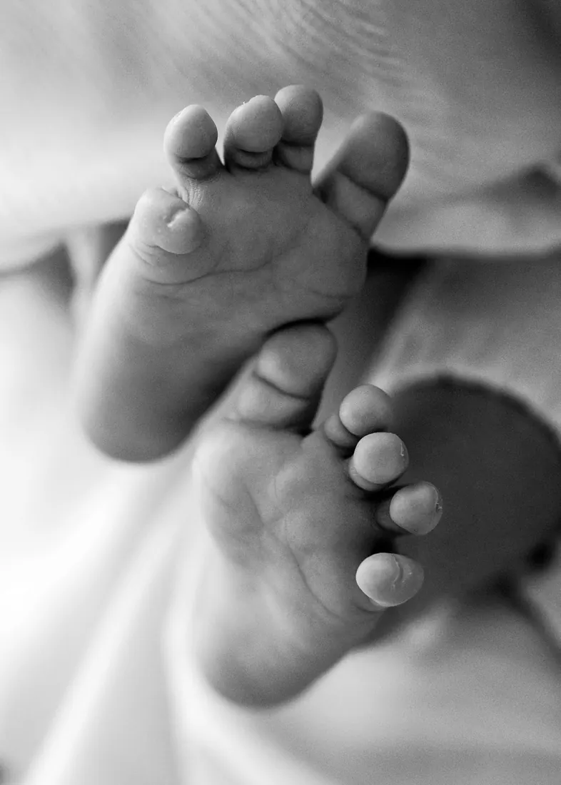Black and white close-up of a newborn’s crossed feet