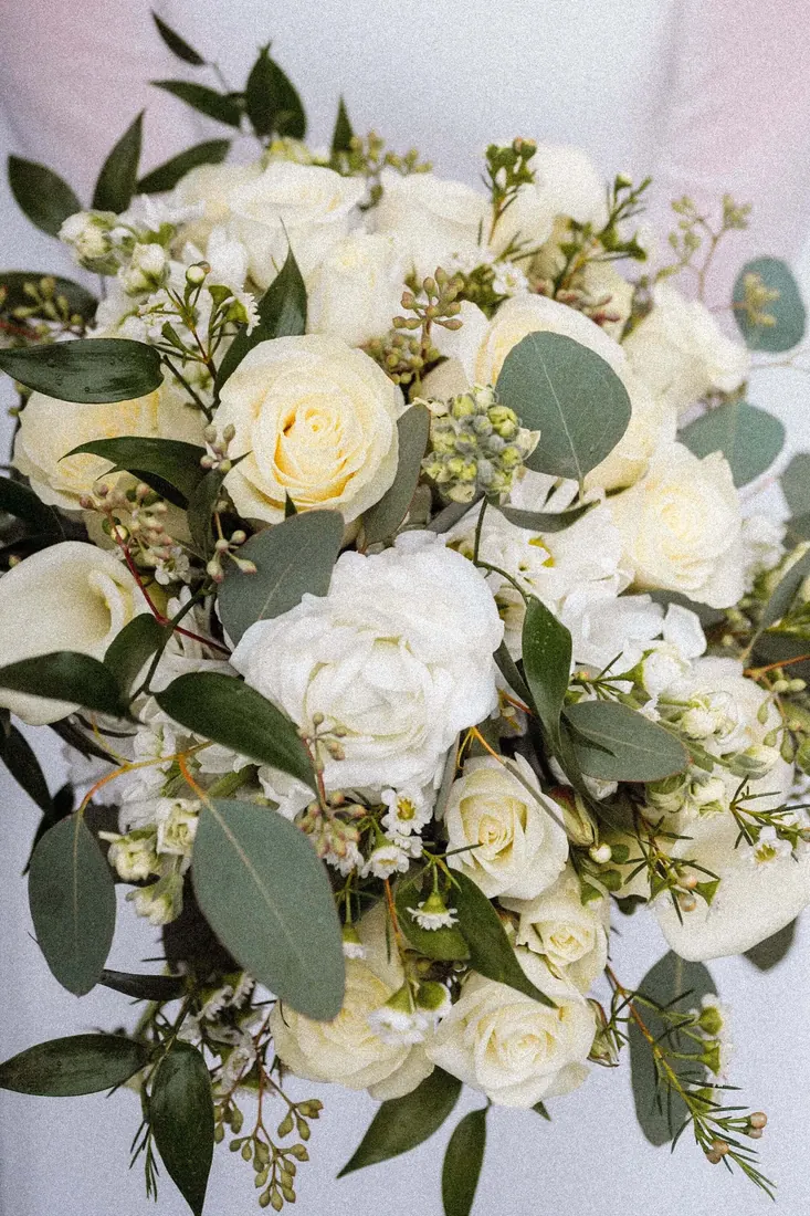 A white garden-rose bouquet held by the bride