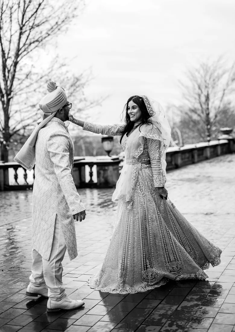 A couple walking in the rain on their wedding day, black and white