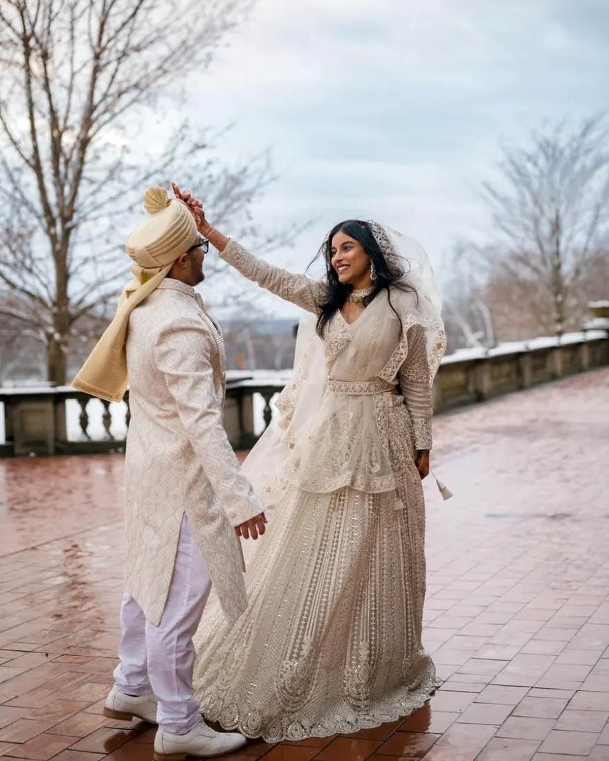 A groom lifting his bride’s veil on a rain-wet terrace